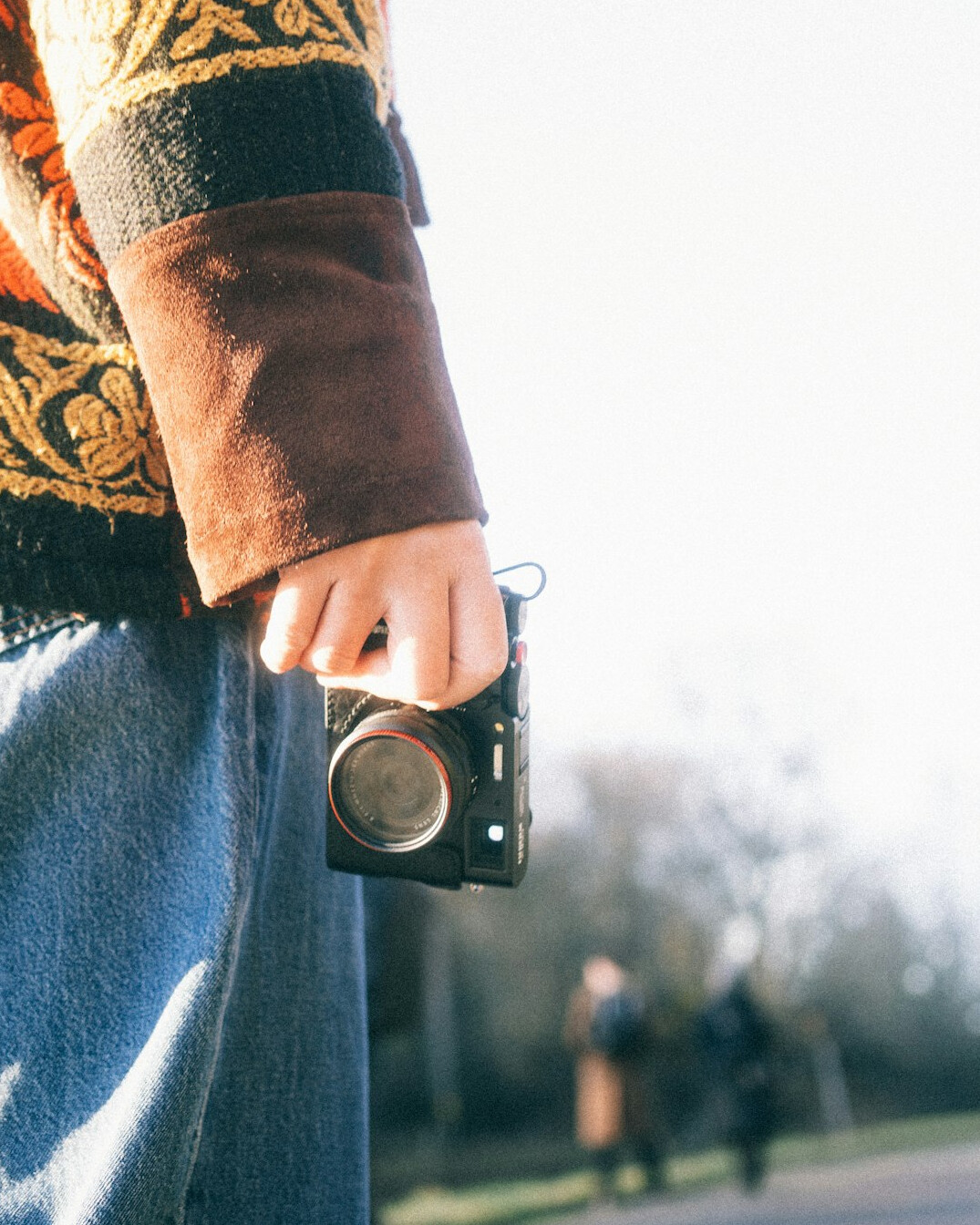 Hands holding an old film camera outdoors